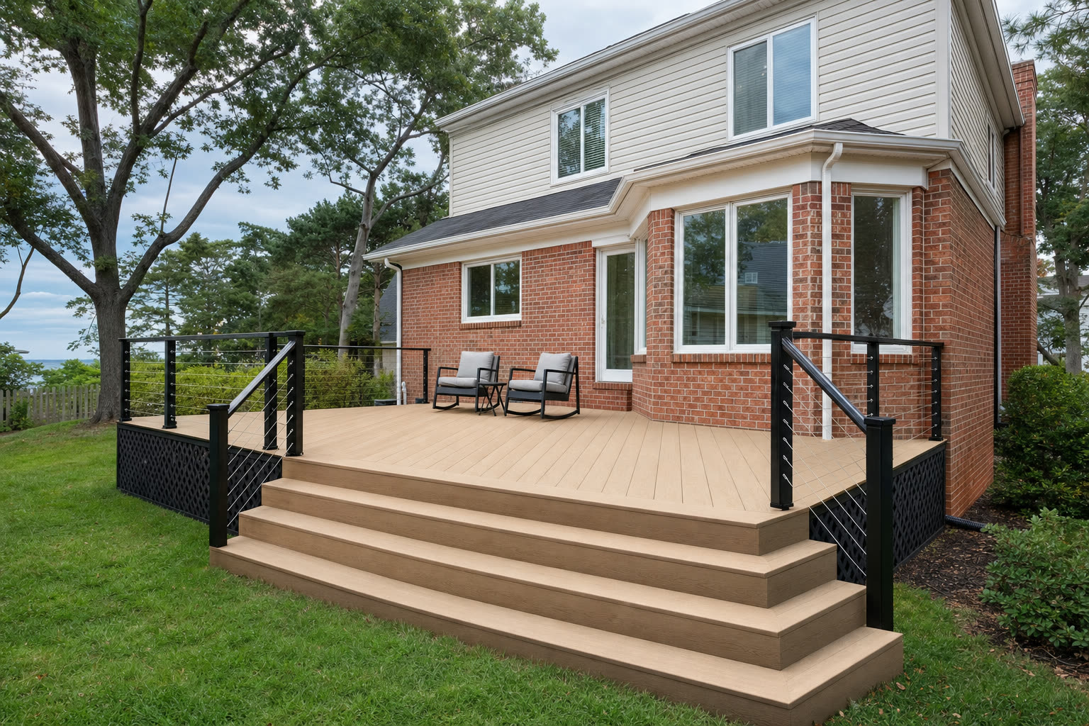 A composite deck on a Virginia brick home shown with warm tan coloured boards
