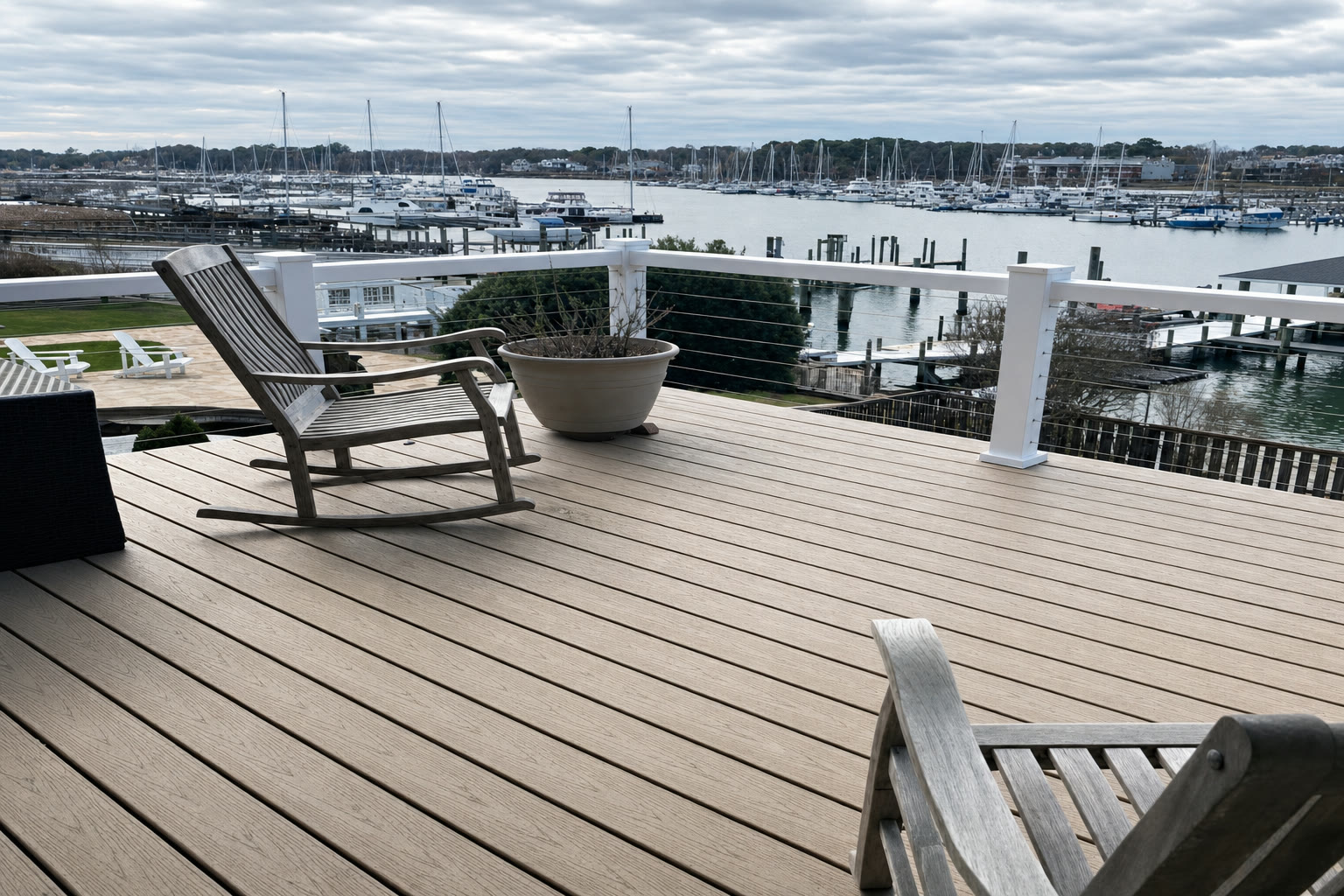 A waterfront composite deck with stainless cable railing overlooking a Hampton Roads marina, built by American Composite Deck Pros
