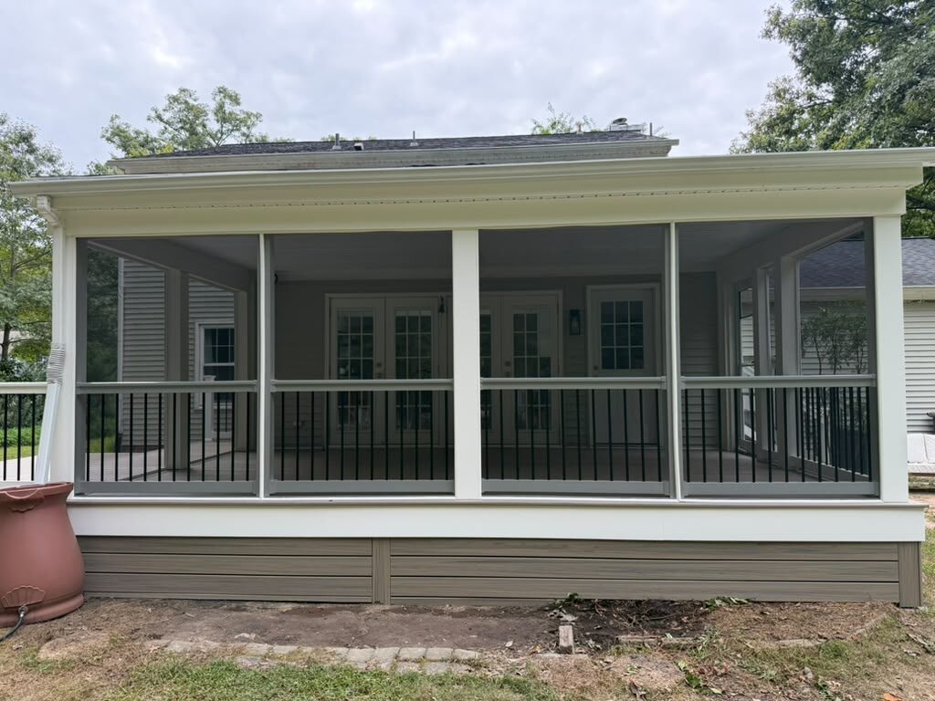 Screened room with black balusters over a Trex Honey Grove deck, built by American Composite Deck Pros